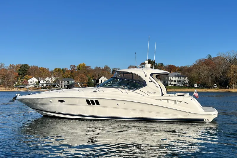 Slide: The Image of 2007 Sea Ray 440 Sundancer yacht on calm water, clear blue sky background. - 0