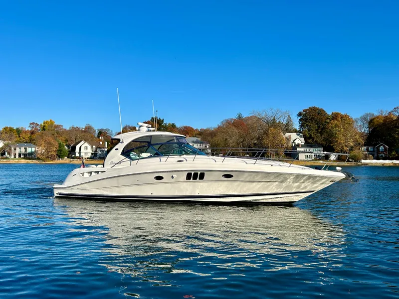 Slide: The Image of 2007 Sea Ray 440 Sundancer yacht on calm water, clear blue sky background. - 1