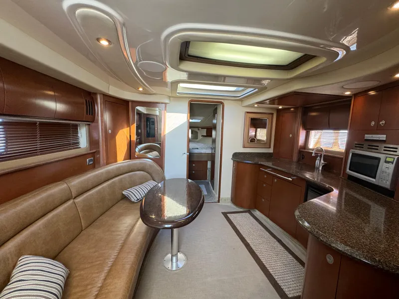 Slide: The Image of Luxurious interior of 2007 Sea Ray 440 Sundancer yacht with modern kitchen and seating area. - 13