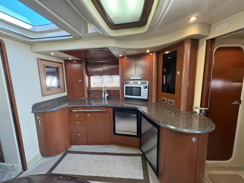 Slide: The Image of Luxurious 2007 Sea Ray 440 Sundancer yacht kitchen with modern appliances and elegant wood cabinetry. - 16