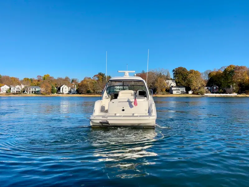 Slide: The Image of Sea Ray 440 Sundancer 2007 yacht on calm water with scenic shoreline background. - 2