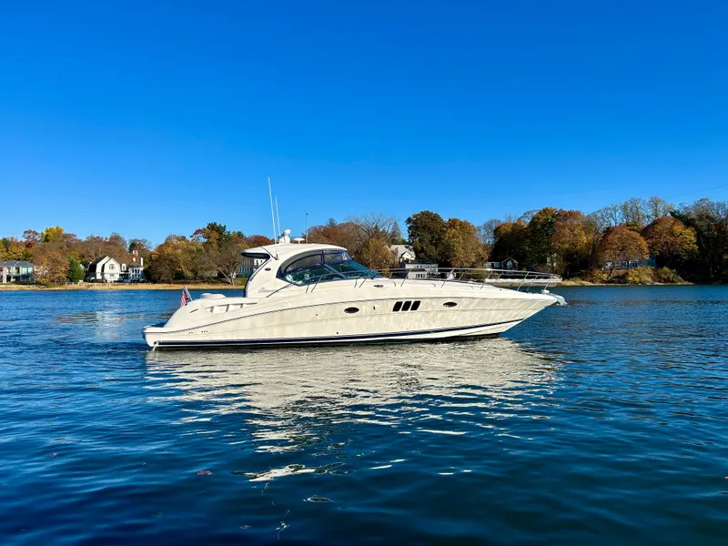 Slide: The Image of 2007 Sea Ray 440 Sundancer yacht cruising on a serene lake under clear blue skies. - 3