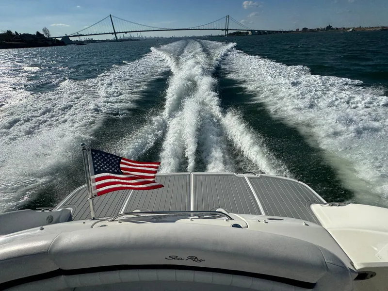 Slide: The Image of Sea Ray 440 Sundancer 2007 cruising with American flag, bridge in background. - 4