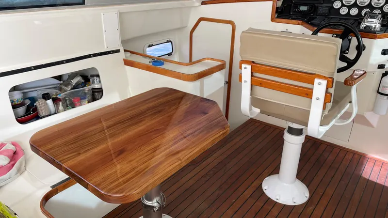 Slide: The Image of Interior of 2004 Roger Hill 9.5M boat with wooden table and captain's chair. - 2