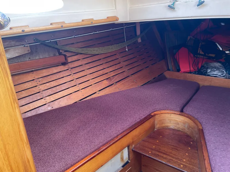 Slide: The Image of Interior of 1961 Sparkman & Stephens Pipe Dream Cruising Sloop with wooden finish and purple cushions. - 11