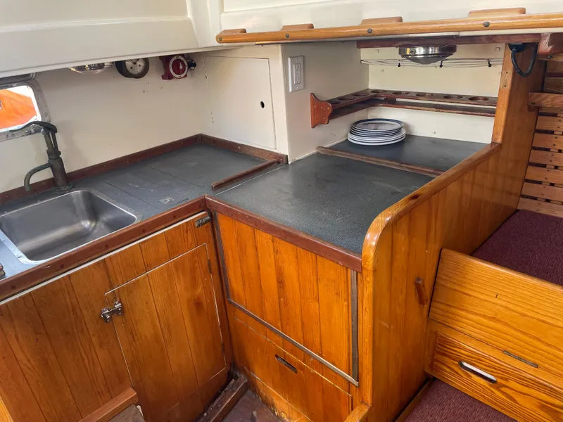 Slide: The Image of 1961 Sparkman & Stephens Pipe Dream Cruising Sloop galley with wooden cabinetry and sink. - 13