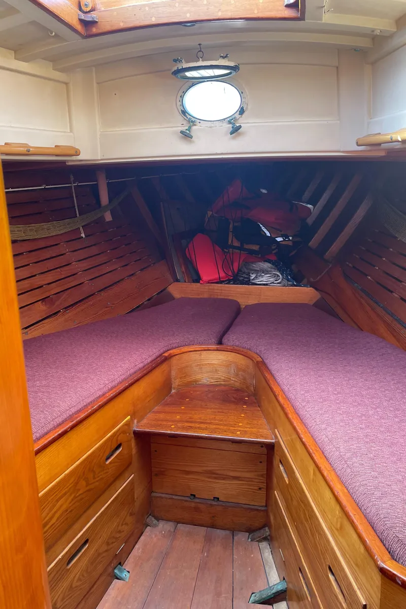 Slide: The Image of Interior of 1961 Sparkman & Stephens Pipe Dream Cruising Sloop with wooden finish and purple cushions. - 17