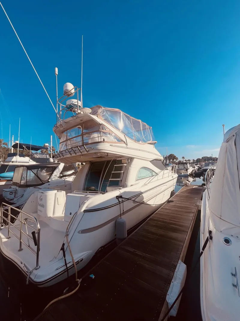Slide: The Image of 1999 Maxum 4100 SCB yacht docked at marina under clear blue sky. - 1