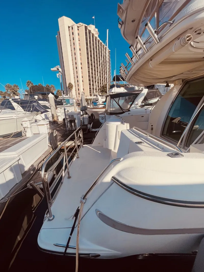 Slide: The Image of 1999 Maxum 4100 SCB yacht docked at marina with cityscape background. - 13