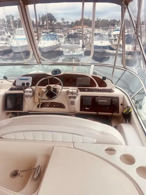 Slide: The Image of 1999 Maxum 4100 SCB yacht helm with marina view, featuring navigation equipment. - 6