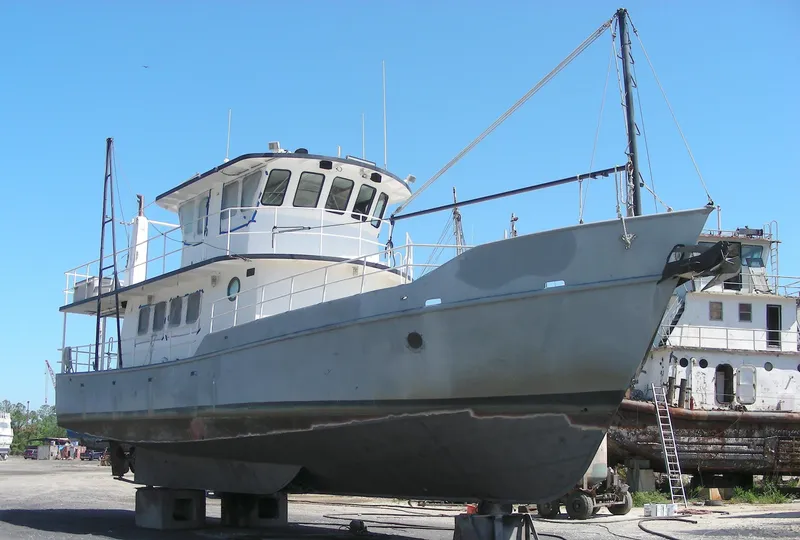 Slide: The Image of Custom 2000 Expedition boat cruising on a calm river under a clear sky. - 1