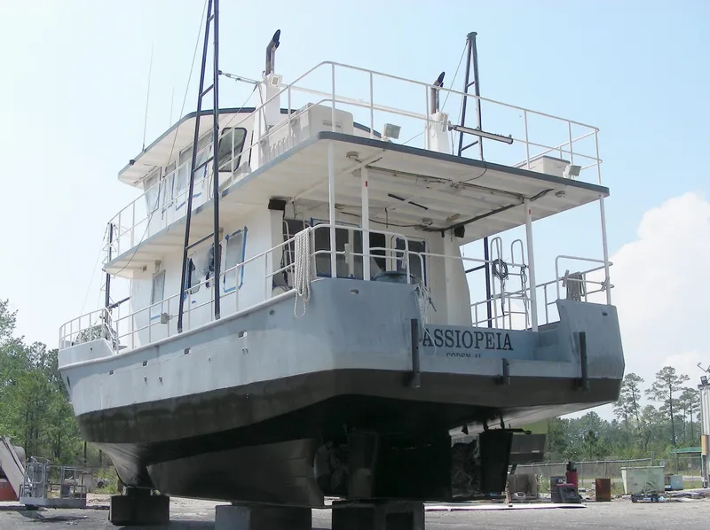 Slide: The Image of Custom 2000 Expedition boat on dry dock for maintenance under clear blue sky. - 2