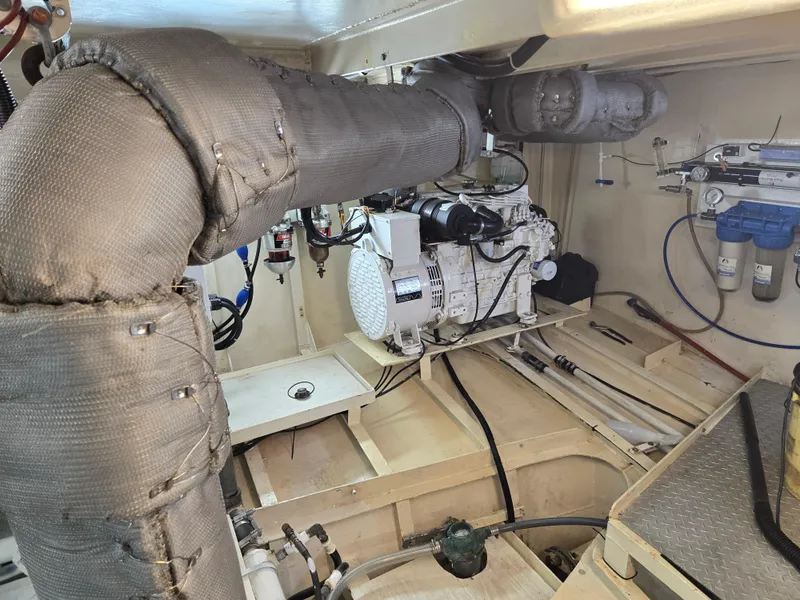 Slide: The Image of Engine room with a 2000 Expedition custom generator, featuring insulated exhaust pipes. - 21