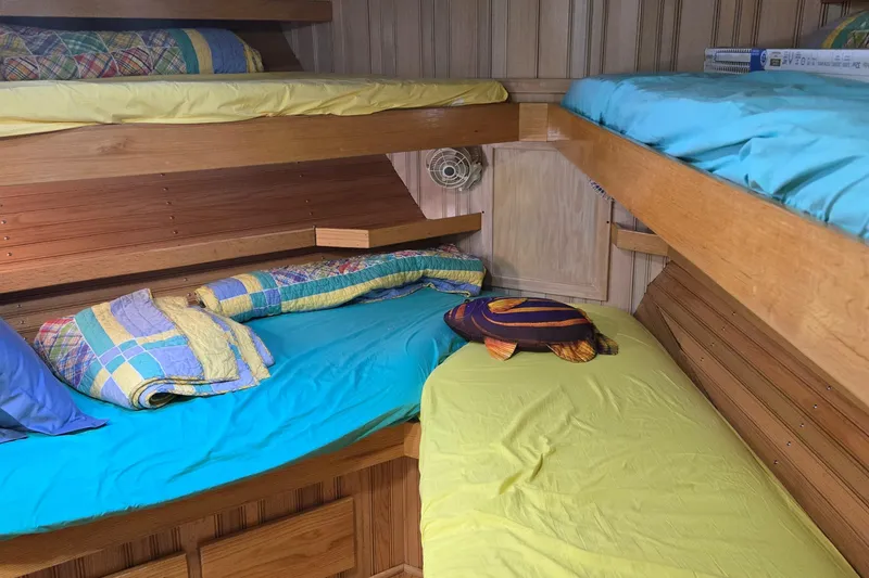 Slide: The Image of Custom 2000 Expedition interior with wooden bunk beds and colorful bedding. - 39