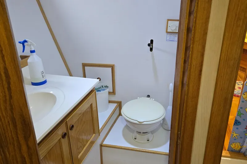 Slide: The Image of Interior of a 2000 Expedition custom boat with wood cabinetry and floral bedding. - 45