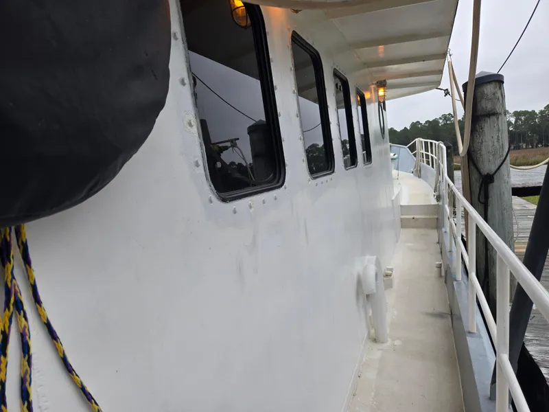 Slide: The Image of Pilot house of a 2000 Expedition custom boat with large windows and white exterior. - 6