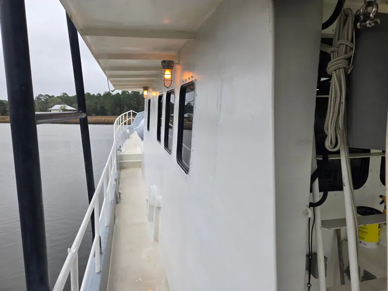 Slide: The Image of Side view of a 2000 Expedition custom boat docked, showing windows and railing. - 7