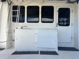 Slide: The Image of Side view of a 2000 Expedition custom boat docked by a calm river. - 8