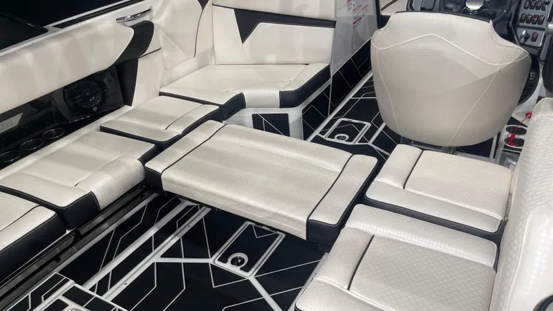 Slide: The Image of 2024 Supreme S220 boat interior with modern white seating and geometric black flooring. - 21