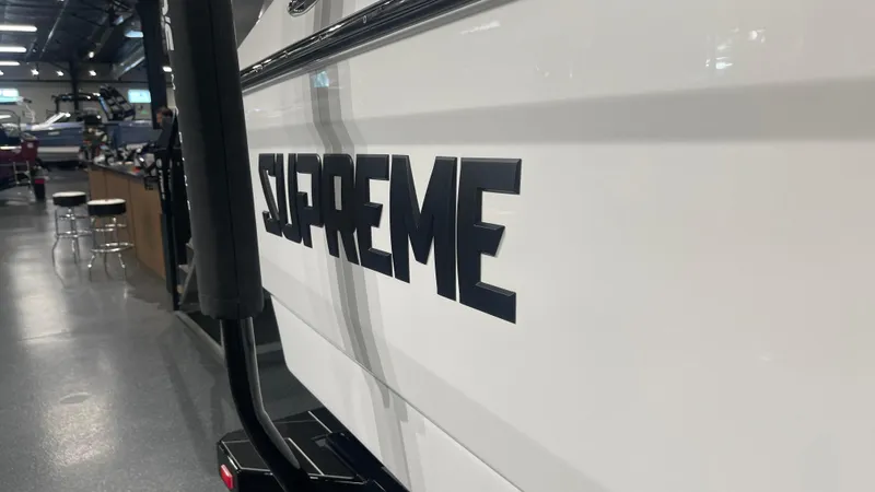 Slide: The Image of 2024 Supreme S220 boat in showroom, showcasing sleek design and branding. - 7