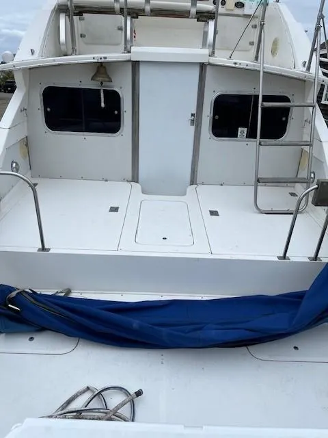Slide: The Image of 1982 Bertram 28 Flybridge boat deck with blue cover and ladder. - 2