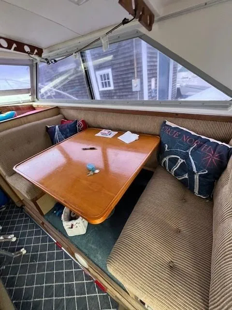 Slide: The Image of Cozy interior of 1982 Bertram 28 Flybridge with cushioned seating and wooden table. - 7