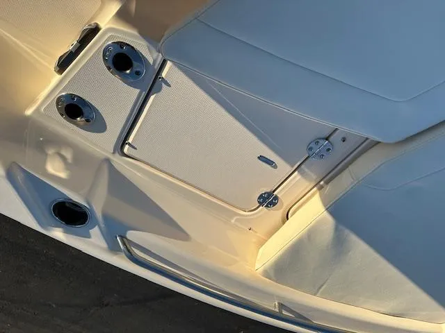 Slide: The Image of 2025 Grady-White 231 Coastal Explorer boat interior, featuring storage compartments and cup holders. - 26