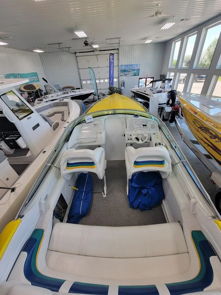 Slide: The Image of 1998 Formula 353 FASTech boat interior in showroom, featuring white and blue seating. - 10
