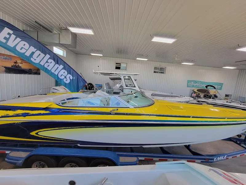 Slide: The Image of 1998 Formula 353 FASTech boat with vibrant yellow and blue design in showroom. - 3
