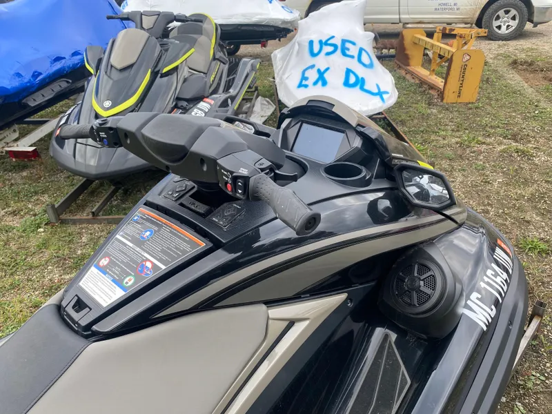 Slide: The Image of 2023 Yamaha WaveRunner FX Cruiser SVHO, black, parked outdoors with other jet skis. - 5