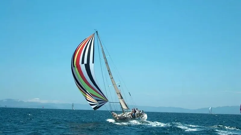 Slide: The Image of Sailing yacht Cheoy Lee Pedrick 38w, 1985, with colorful spinnaker on open sea. - 2