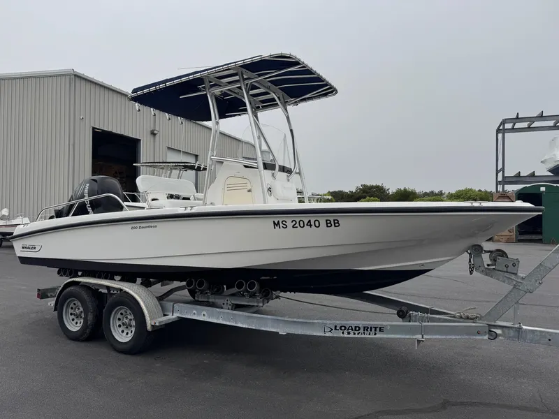Slide: The Image of 2008 Boston Whaler 200 Dauntless boat on trailer, parked outside a warehouse. - 3