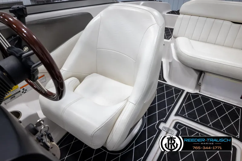Slide: The Image of 2008 Regal 1900 boat interior with white seating and black diamond-patterned flooring. - 21