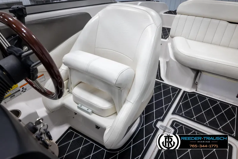 Slide: The Image of 2008 Regal 1900 boat interior with white leather seats and black diamond-patterned flooring. - 22