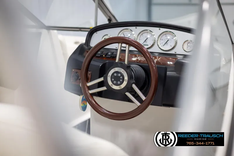 Slide: The Image of 2008 Regal 1900 boat dashboard with wooden steering wheel and gauges. - 25