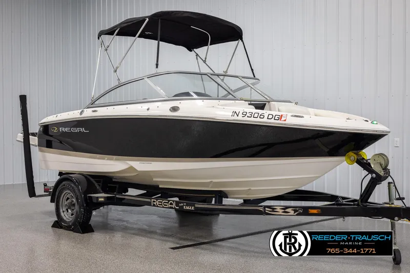 Slide: The Image of 2008 Regal 1900 boat on trailer with black canopy in indoor showroom. - 3