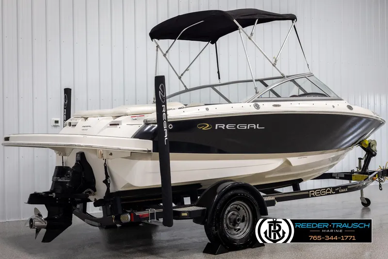 Slide: The Image of 2008 Regal 1900 boat with black and white design on a trailer in a showroom. - 7