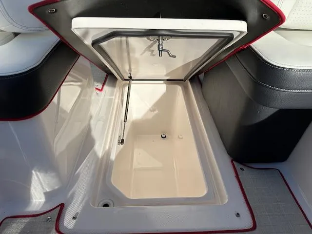 Slide: The Image of 2025 Regal LS9 Surf boat storage compartment with open lid. - 16