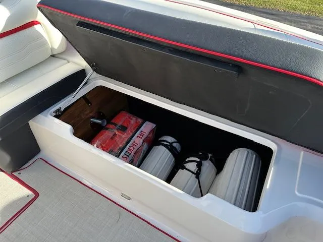 Slide: The Image of 2025 Regal LS9 Surf boat storage compartment with life jackets and fenders. - 28