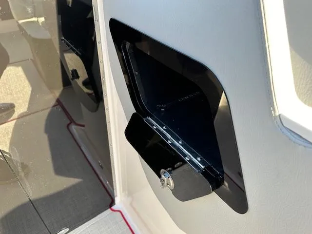 Slide: The Image of 2025 Regal LS9 Surf boat interior storage compartment with sleek black finish. - 36