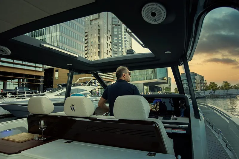 Slide: The Image of Man steering 2025 Wiszniewski Yachts W43 in urban marina at sunset. - 6