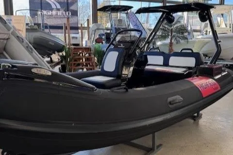 Slide: The Image of 2025 Highfield Jet 420 boat displayed in showroom, black exterior, modern design. - 2