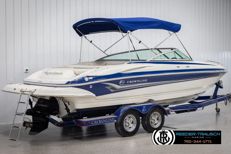 Slide: The Image of 2006 Crownline 230 LS boat with blue canopy on trailer in showroom. - 6
