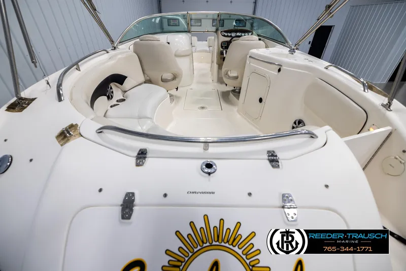 Slide: The Image of 2002 Chaparral 243 Sunesta boat interior with seating and dashboard, displayed in a showroom. - 13
