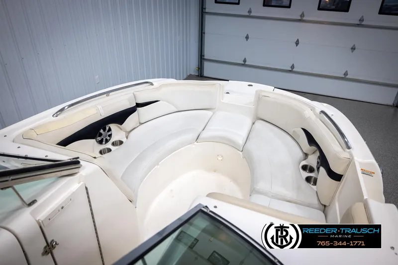 Slide: The Image of 2002 Chaparral 243 Sunesta boat interior with white seating and cup holders. - 19
