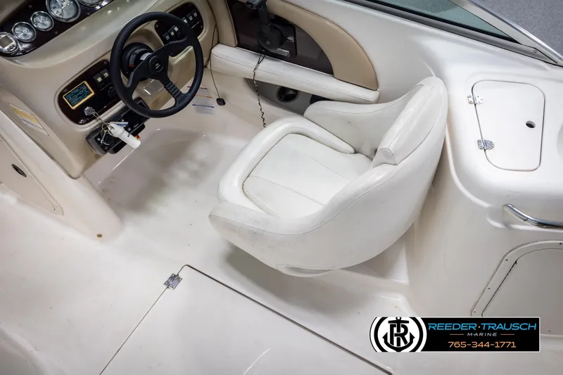 Slide: The Image of 2002 Chaparral 243 Sunesta boat cockpit with steering wheel and white captain's chair. - 21