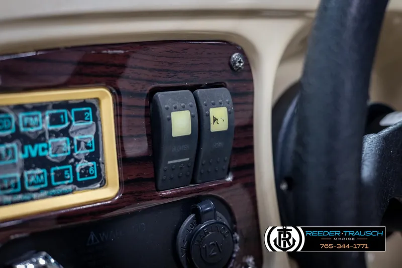 Slide: The Image of Dashboard of a 2002 Chaparral 243 Sunesta boat with control switches and JVC panel. - 32