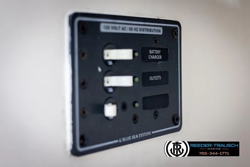 Slide: The Image of Electrical panel on 2002 Chaparral 243 Sunesta boat, featuring battery charger and outlets. - 42