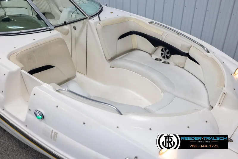 Slide: The Image of 2002 Chaparral 243 Sunesta boat interior with white seating and cup holders. - 9
