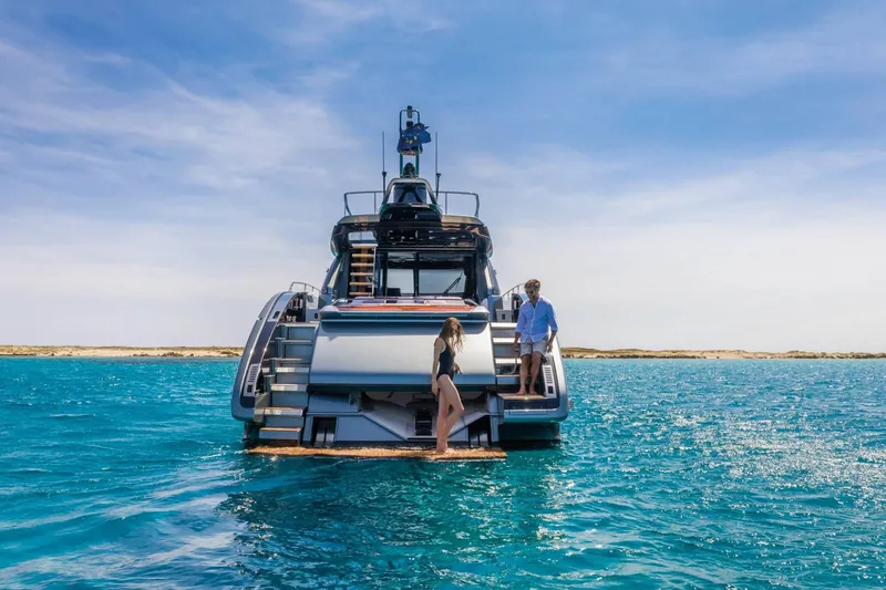 Slide: The Image of 2024 Riva 66' Ribelle yacht on open water with two people on deck. - 14